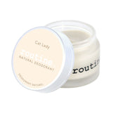 routine Cat Lady deodorant jar opened - showing smooth white cream texture inside glass container with "Cat Lady Natural Deodorant" label for coconut vanilla scented formula